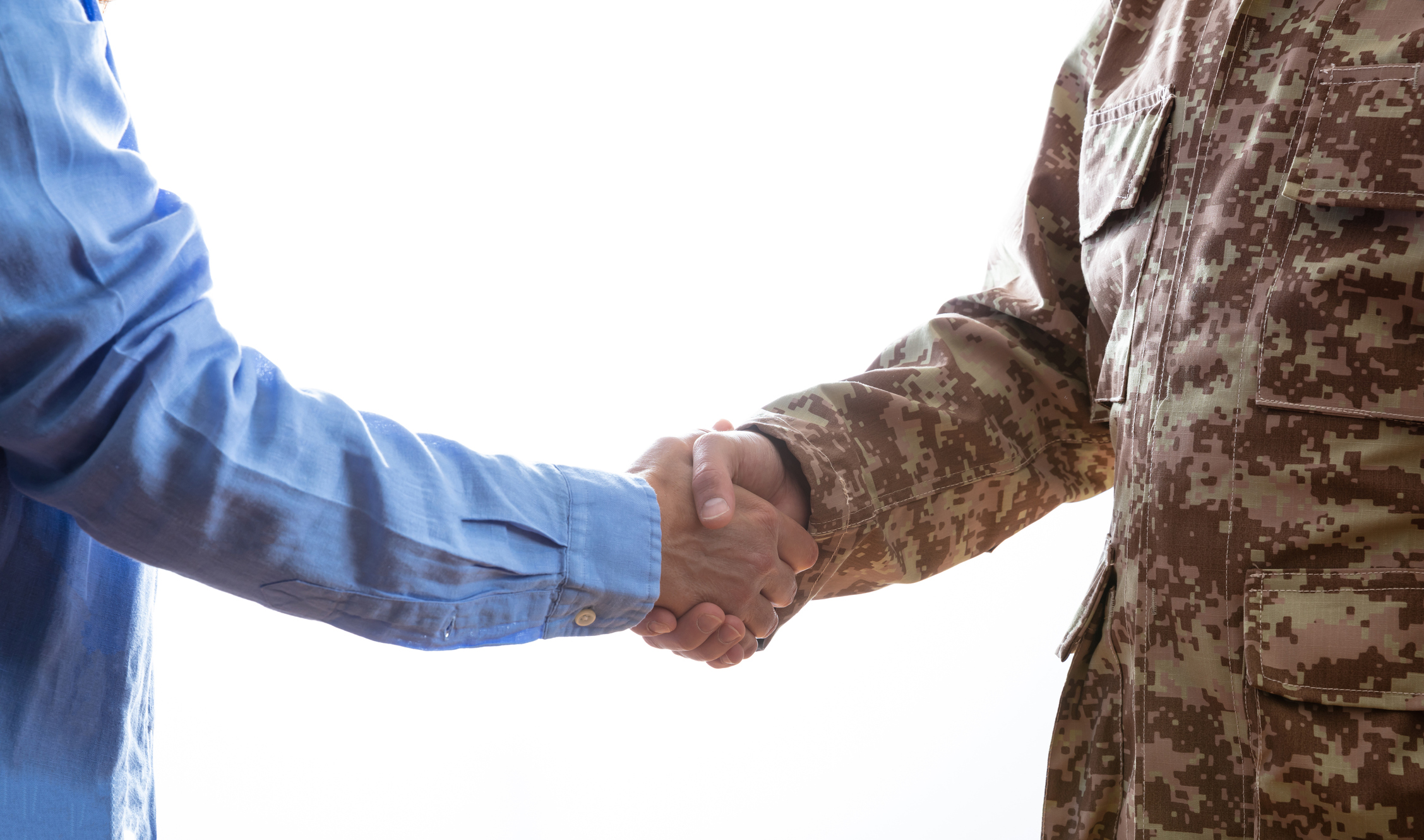 Military and civilian shaking hands standing on white background